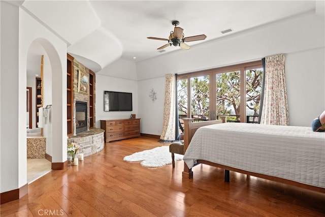 4117 Vanetta Pl, Studio City, CA 91604 - bedroom featuring hardwood / wood-style flooring, a stone fireplace, lofted ceiling, and a ceiling fan