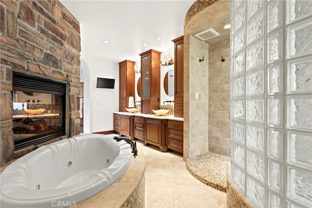 4117 Vanetta Pl, Studio City, CA 91604 - bathroom with a tub with jets, a walk in shower, double vanity, a stone fireplace, and recessed lighting