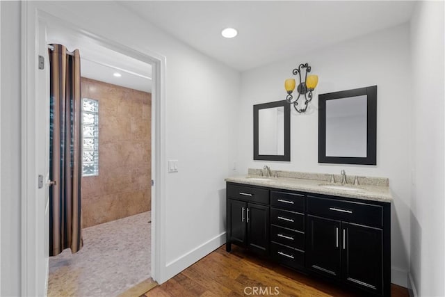 4117 Vanetta Pl, Studio City, CA 91604 - full bath featuring wood finished floors, double vanity, baseboards, recessed lighting, and tiled shower