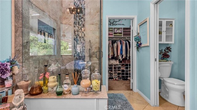 74078 W Petunia Pl, Palm Desert, CA 92211 - bathroom with toilet, tile patterned flooring, a walk in closet, and a shower