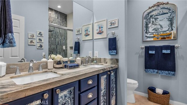74078 W Petunia Pl, Palm Desert, CA 92211 - bathroom with toilet, double vanity, a stall shower, tile patterned flooring, and baseboards
