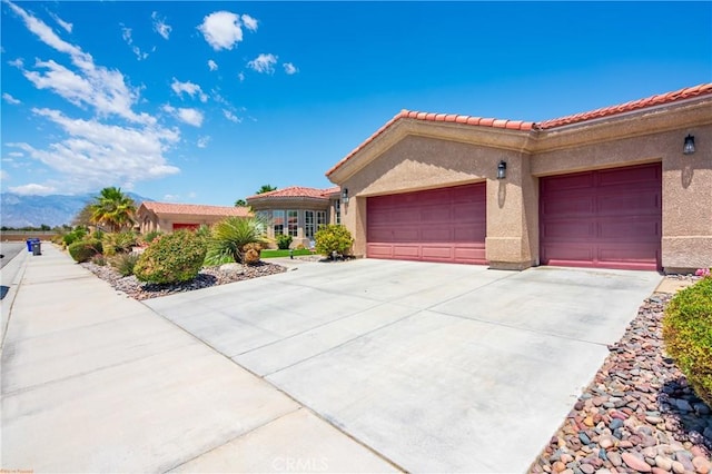 74078 W Petunia Pl, Palm Desert, CA 92211 - view of front of property with a garage, stucco siding, driveway, and a tiled roof