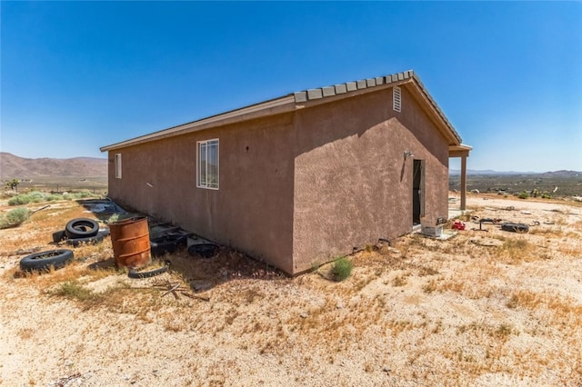 8975 Pumalo Rd, Lucerne Valley, CA 92356 - view of side of property with a mountain view and stucco siding