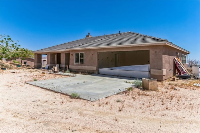 8975 Pumalo Rd, Lucerne Valley, CA 92356 - back of house with a tiled roof, stucco siding, a garage, and a chimney