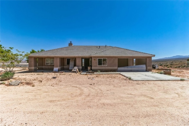 8975 Pumalo Rd, Lucerne Valley, CA 92356 - ranch-style house featuring a tile roof, driveway, a mountain view, a chimney, and stucco siding
