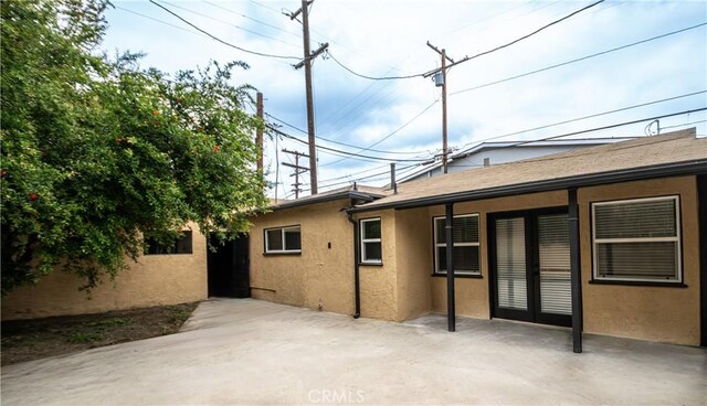 rear view of house featuring stucco siding and a patio