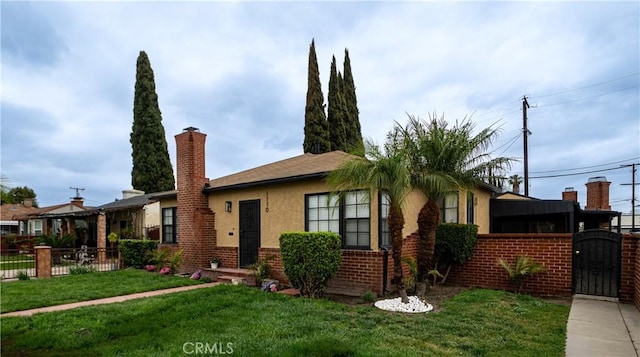 view of front of home with stucco siding, a gate, a chimney, and brick siding