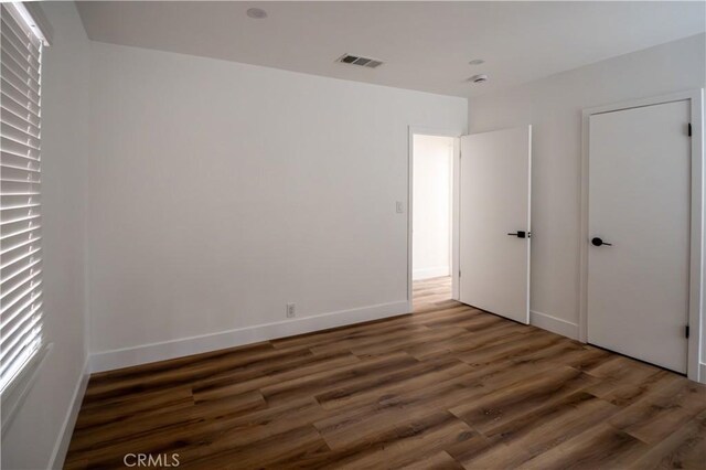 unfurnished bedroom with wood finished floors and baseboards