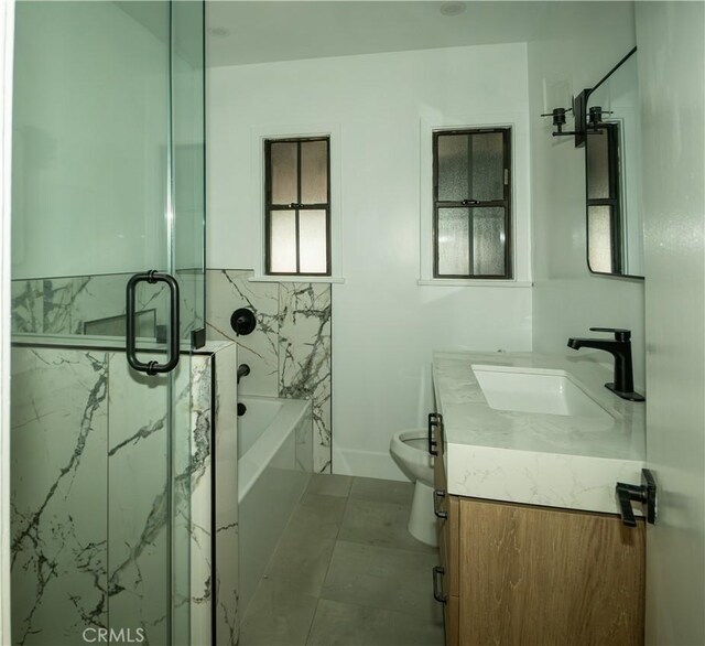 full bathroom featuring a marble finish shower, vanity, a bathtub, and toilet