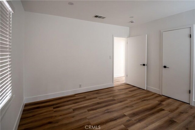 unfurnished bedroom with wood finished floors and baseboards