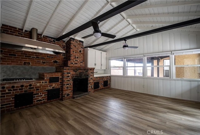 unfurnished living room with wood finished floors, lofted ceiling, a wood stove, and ceiling fan
