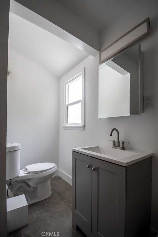 bathroom featuring toilet, baseboards, and vanity