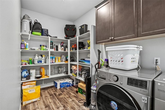 laundry area with cabinet space, independent washer and dryer, and wood finished floors