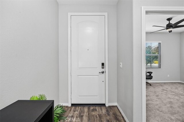 entryway featuring a ceiling fan, baseboards, and dark wood-type flooring