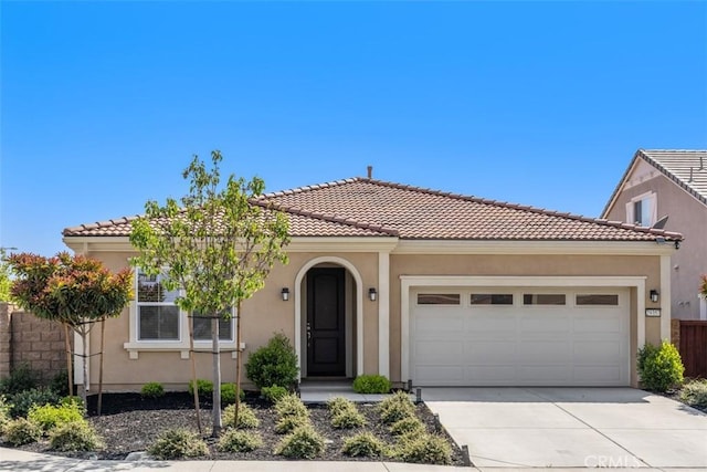 mediterranean / spanish-style home featuring driveway, an attached garage, and a tiled roof