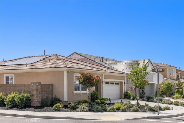 view of front of house with an attached garage, stucco siding, a tiled roof, and driveway
