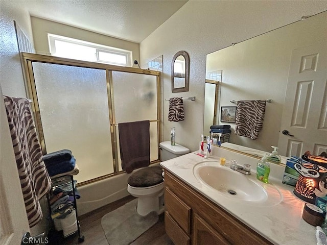 14402 Boxtree St, Lake Hughes, CA 93532 - bathroom featuring toilet, bath / shower combo with glass door, vanity, a textured wall, and wood finished floors