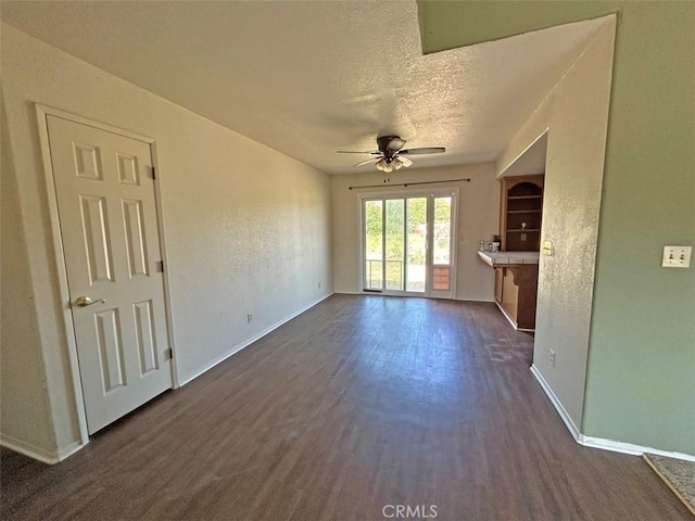 14402 Boxtree St, Lake Hughes, CA 93532 - unfurnished living room with a ceiling fan, a textured ceiling, and dark wood-type flooring