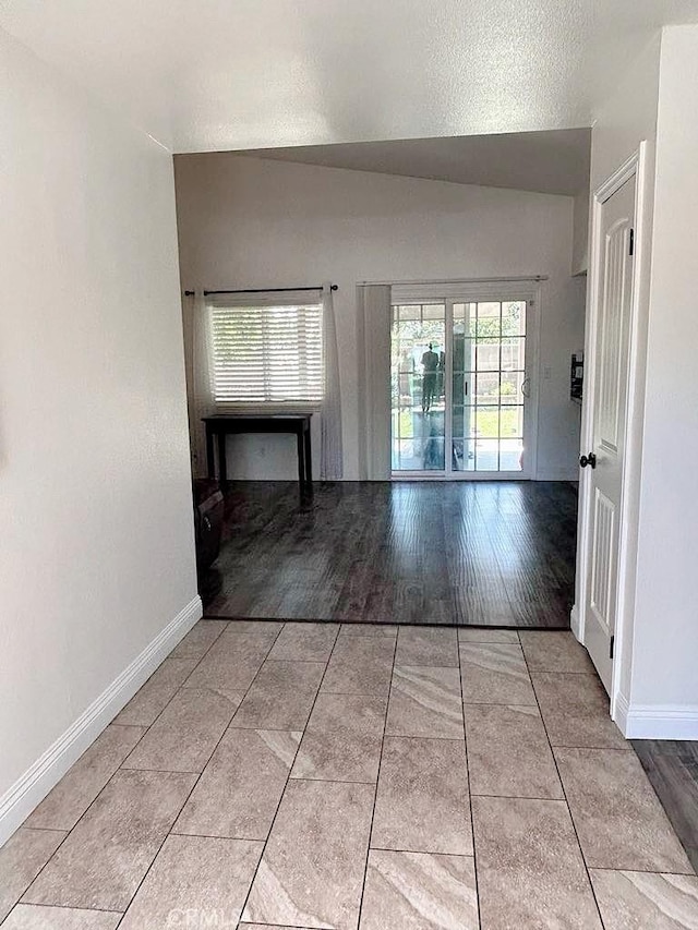 16045 Jackson Dr, Fontana, CA 92336 - hall with plenty of natural light, baseboards, light tile patterned floors, and lofted ceiling