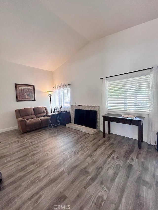 16045 Jackson Dr, Fontana, CA 92336 - living area featuring vaulted ceiling, wood finished floors, a fireplace with raised hearth, and baseboards