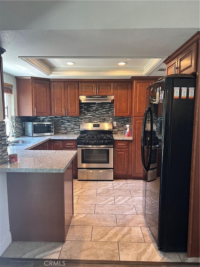 16045 Jackson Dr, Fontana, CA 92336 - kitchen featuring appliances with stainless steel finishes, a tray ceiling, a sink, under cabinet range hood, and recessed lighting