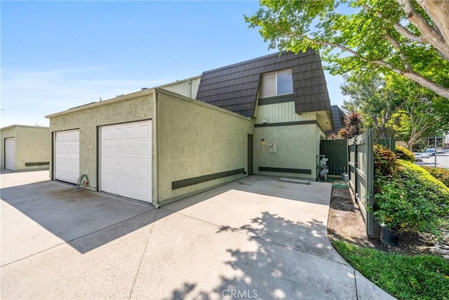 1622 Iowa St Unit A, Costa Mesa, CA 92626 - view of front of home with mansard roof, a garage, and stucco siding