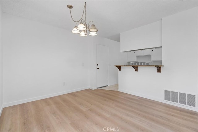 1622 Iowa St Unit A, Costa Mesa, CA 92626 - unfurnished dining area featuring a chandelier, light wood finished floors, and baseboards