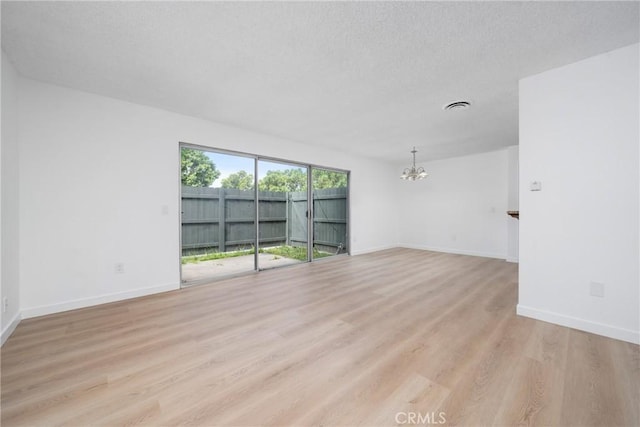 1622 Iowa St Unit A, Costa Mesa, CA 92626 - spare room with a chandelier, light wood-style flooring, baseboards, and a textured ceiling