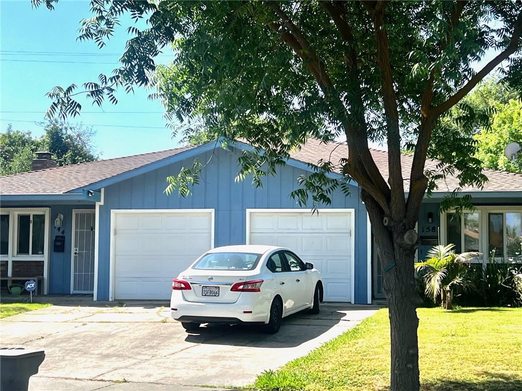 158 W Alexander Ave, Merced, CA 95348 - view of front of property with an attached garage, concrete driveway, a shingled roof, and a front lawn