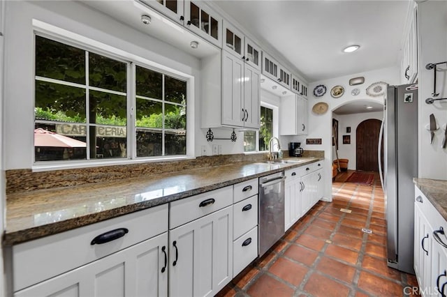 22658 Arriba Dr, Saugus, CA 91350 - kitchen featuring appliances with stainless steel finishes, arched walkways, glass insert cabinets, and white cabinetry