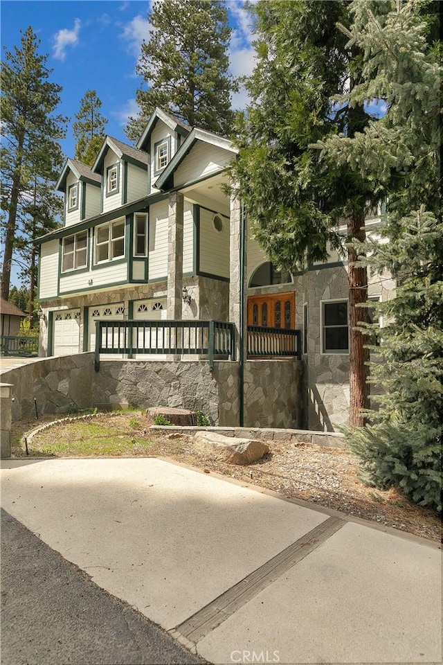 109 S Fairway Dr, Lake Arrowhead, CA 92352 - view of front of home with stone siding, an attached garage, and covered porch