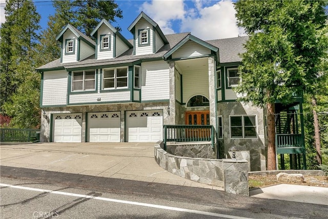 109 S Fairway Dr, Lake Arrowhead, CA 92352 - view of front of home with an attached garage, concrete driveway, stone siding, and a shingled roof