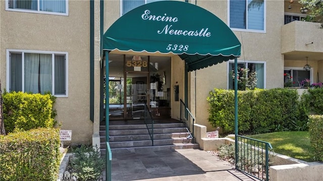 doorway to property featuring stucco siding