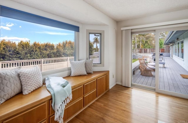 sitting room with light wood-style floors, a textured ceiling, and baseboards