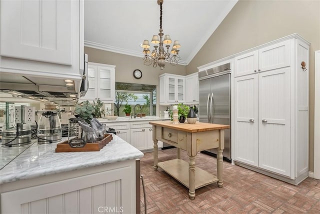 19 Rollins Pl, Laguna Niguel, CA 92677 - kitchen with built in refrigerator, lofted ceiling, crown molding, white cabinets, and glass insert cabinets