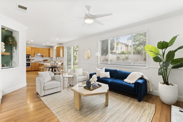 living area featuring crown molding, light wood finished floors, ceiling fan, recessed lighting, and baseboards
