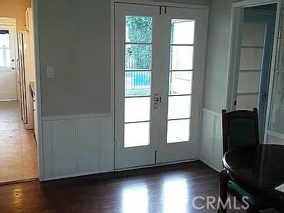 527 S Orchard Dr, Burbank, CA 91506 - doorway featuring french doors, plenty of natural light, wainscoting, dark wood-type flooring, and a decorative wall