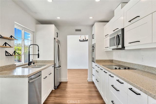 25735 Williamsburg Ct, Lake Forest, CA 92630 - kitchen with stainless steel appliances, a sink, light wood-style flooring, recessed lighting, and white cabinets