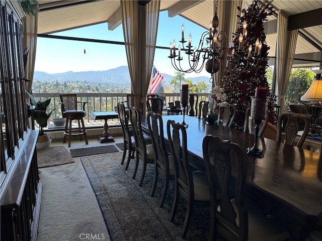 carpeted dining area featuring a chandelier, a mountain view, and plenty of natural light