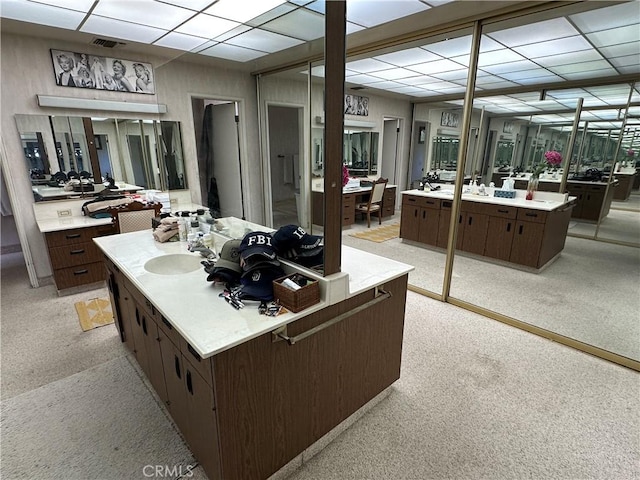 bathroom with a paneled ceiling and vanity