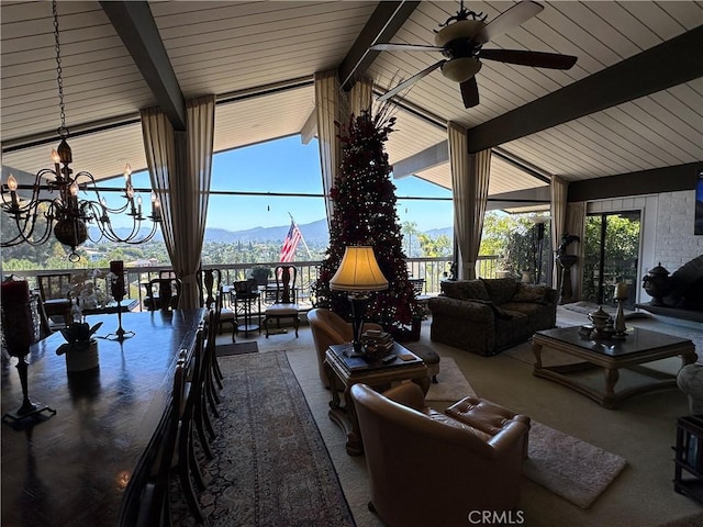 carpeted living room with ceiling fan, a chandelier, and a mountain view