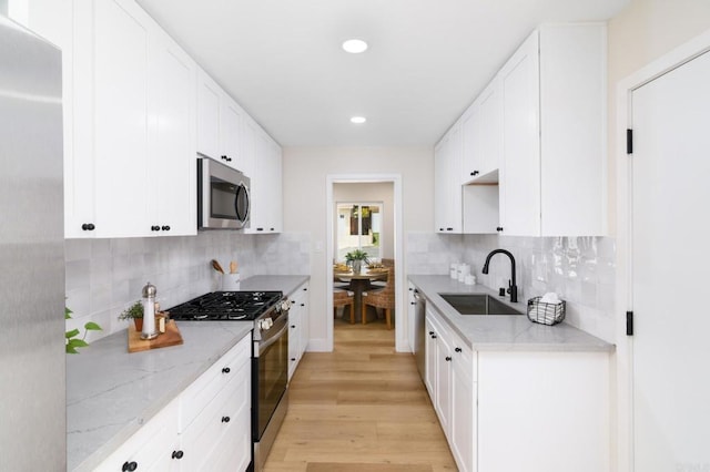 5157 Trinidad Way, San Diego, CA 92114 - kitchen with stainless steel appliances, a sink, light wood finished floors, backsplash, and recessed lighting