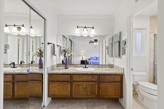 bathroom with ensuite bath, a ceiling fan, toilet, two vanities, and crown molding