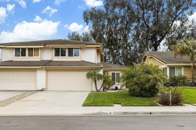 view of front of home featuring concrete driveway, a front yard, a garage, and a tile roof