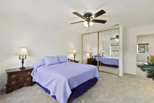 bedroom with carpet flooring, ornamental molding, a closet, a ceiling fan, and baseboards