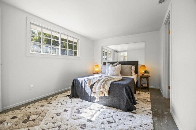 bedroom with baseboards and concrete floors