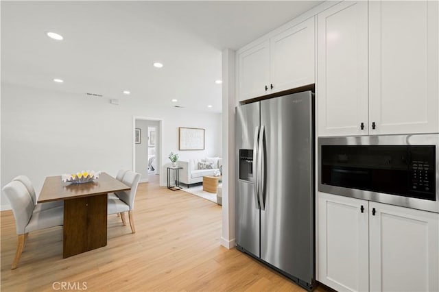 kitchen with appliances with stainless steel finishes, white cabinetry, light wood finished floors, recessed lighting, and baseboards