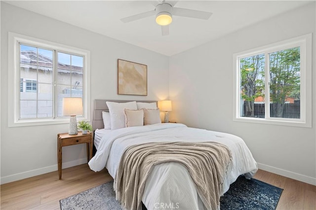 bedroom with baseboards, light wood finished floors, and ceiling fan