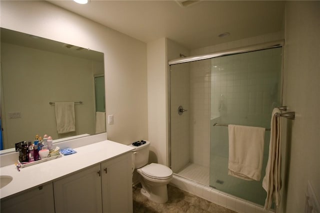 bathroom with toilet, a shower stall, and vanity
