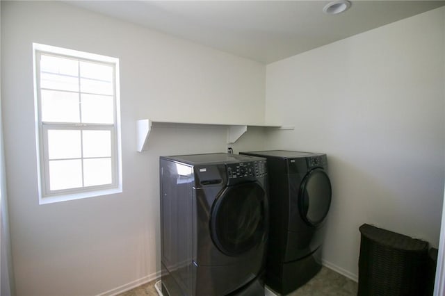clothes washing area featuring washer and dryer and baseboards